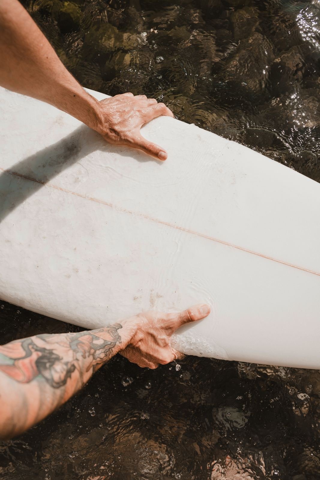 A surfboard resting in the shallows